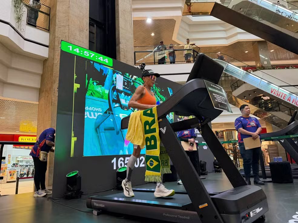 Débora Simas na esteira com a bandeira do Brasil